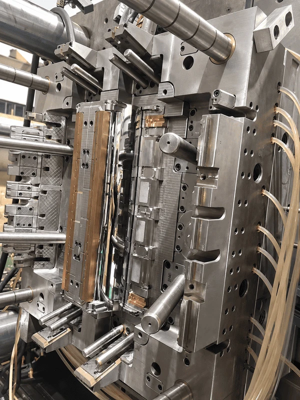 Open large plastic injection mold showing core slides guide components and cooling connections during installation Open large plastic injection mold showing core slides guide components and cooling connections during installation